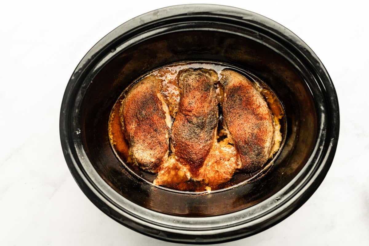 Cooked chicken breasts in a slow cooker